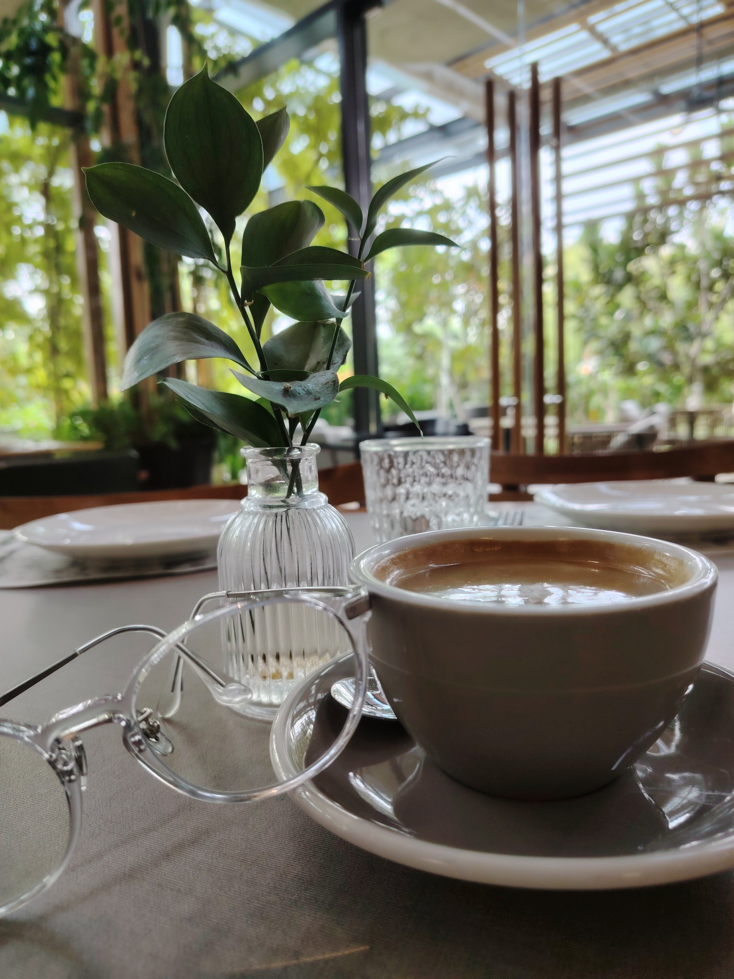 Morning cup of coffee with glasses on a wooden table